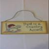 Antique Rustic Wooden "Dust is a Country Accent" Sign painted antique white with a rag doll holding a feather duster and a broom. Measures 9-3/4 x 4-3/4 x 1/4" with a rope hanger. view 1