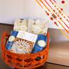Ghasitaram Gifts Rakhi Gifts for Brothers Orange Jute Basket of assortments with Kaju Katli with 5 rakhis view 1