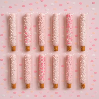 Gender Reveal Pink Chocolate Pretzel Rods with Pink Sprinkles and assorted toppings