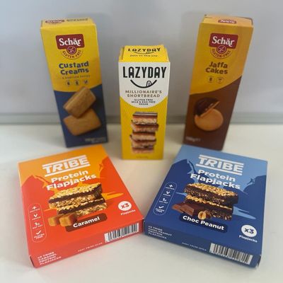 *BRITSH GOODS* GLUTEN FREE Snack Pack/Gift/Hamper *Vegan/Vegetarian* 1 x TRIBE Chocolate Peanut Protein Flapjack (3x38g Ve) 1 x TRIBE Caramel Protein Flapjack (3x38g Ve) 1 x LAZYDAY Millionaires Shortbread, 1 x Schar Custard Creams (Ve125g), 1 x Scha