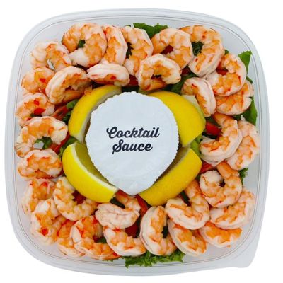 Shrimp Tray with Cocktail Sauce, Shrimp and zesty cocktail sauce in a party ready tray,Its accompanied by fresh lemon wedges, adding a tangy twist to the dish. 1.5 POUND